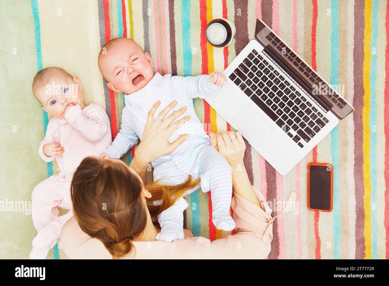 Mutter mit zwei Babys liegend am Boden mittels Laptop, erhöhten Blick Stockfoto