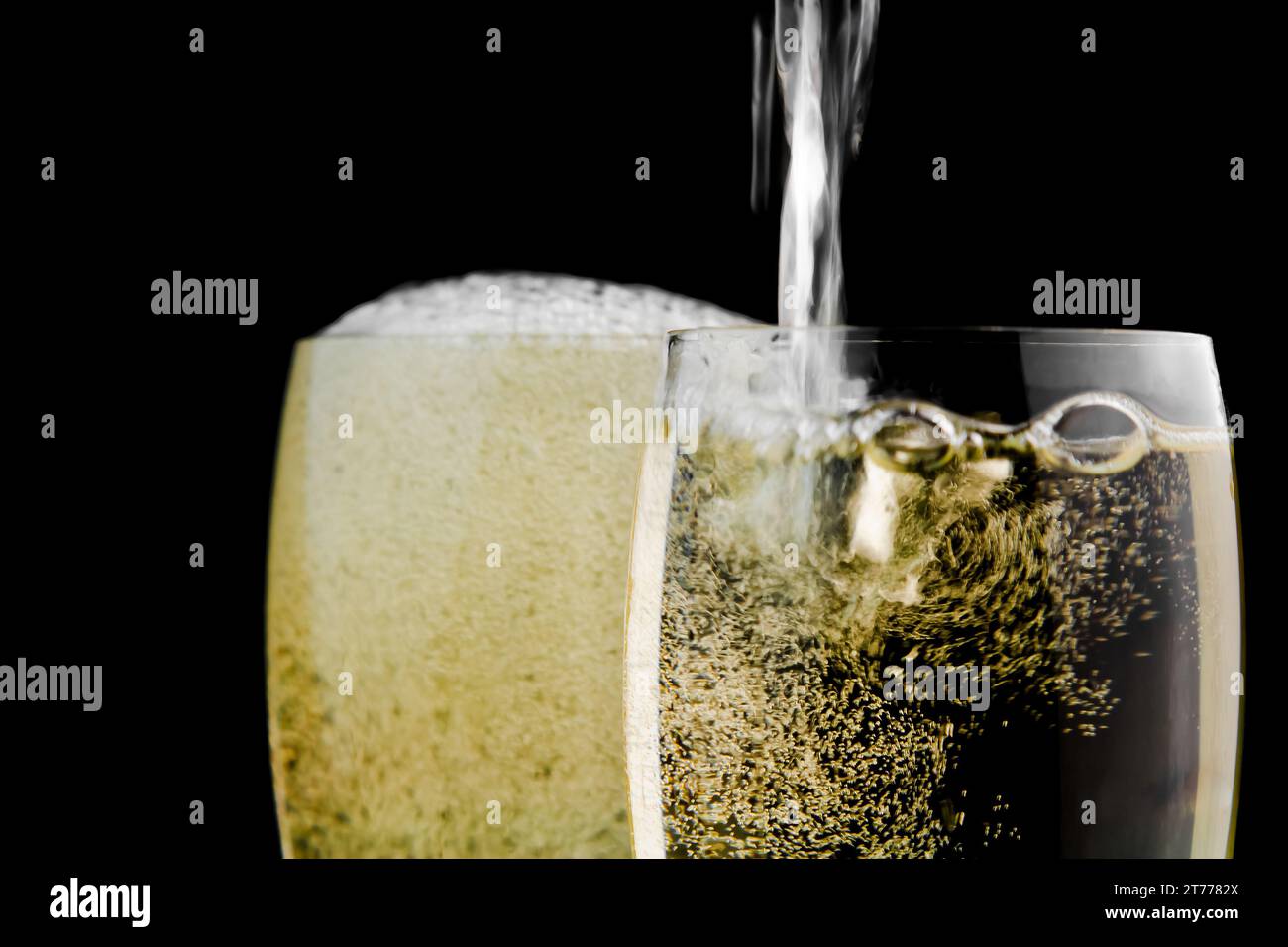 Volle Gläser Champagner und eines vor schwarzem Hintergrund gefüllt Stockfoto