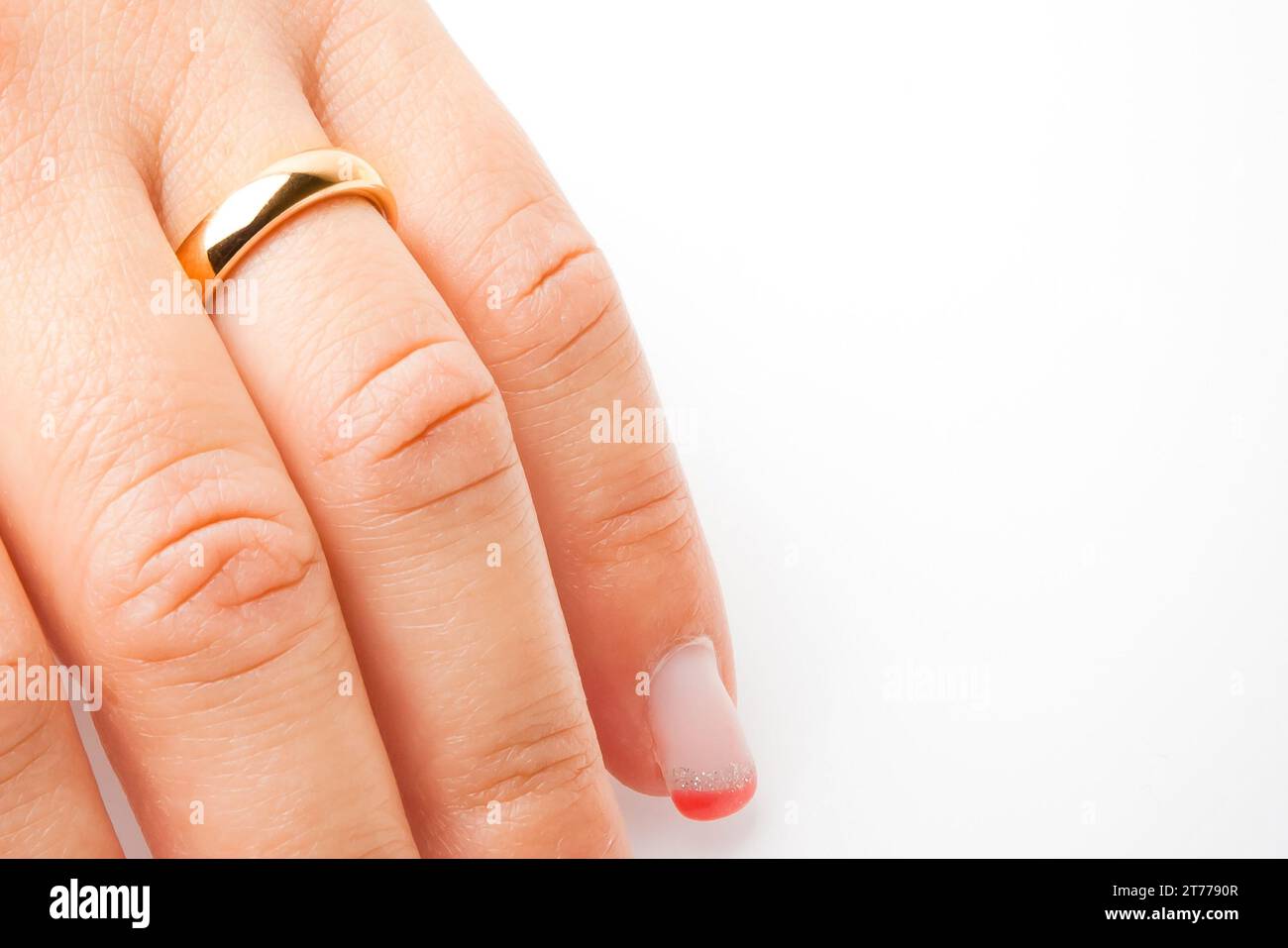 Detail einer Hand mit Goldring mit Platz für Text auf weißem Hintergrund Stockfoto