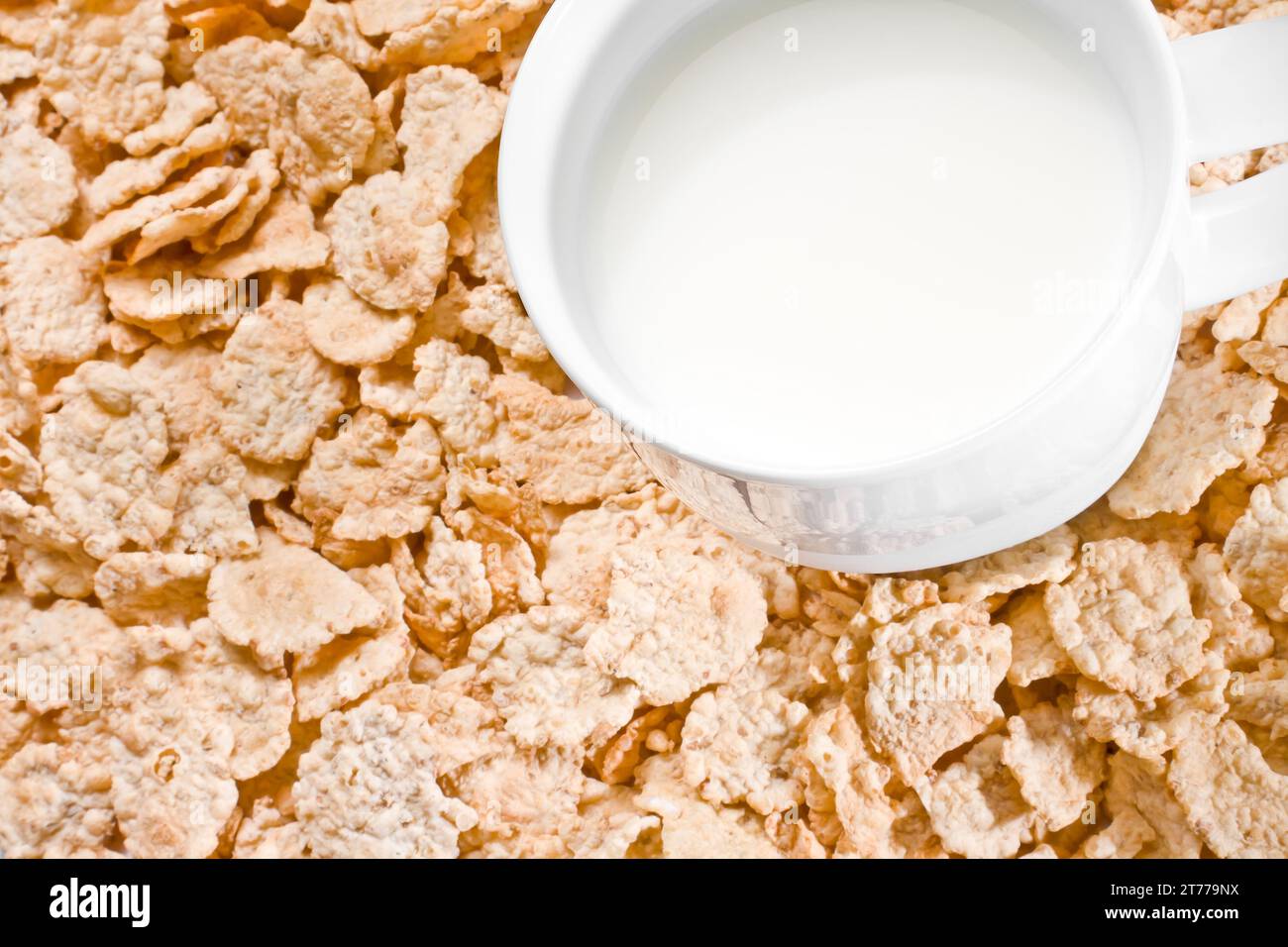 Detail einer Tasse Milch auf Cornflakes Hintergrund, Frühstückskonzept Stockfoto