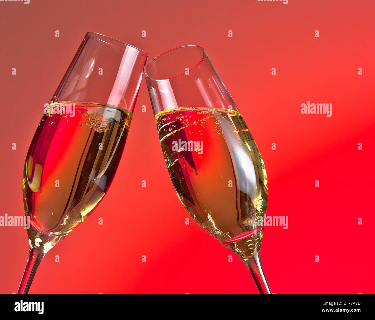Die Details der zwei Sektflöten geben Anfeuerungen auf rotem Hintergrund mit Platz für Text Stockfoto
