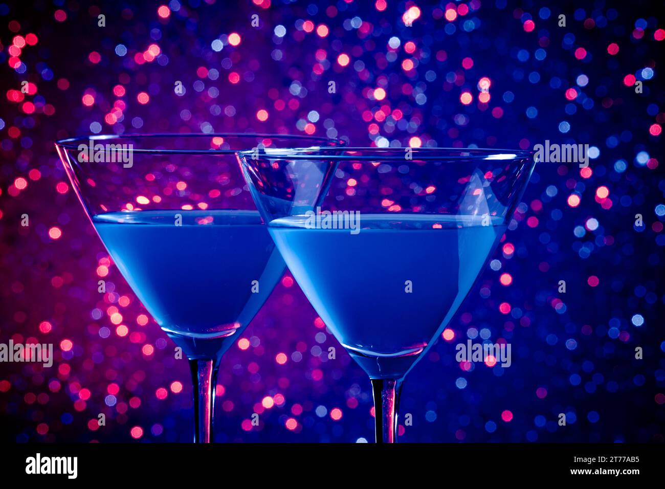 Zwei Gläser blauer Cocktail auf blauem und violettem Hintergrund Stockfoto