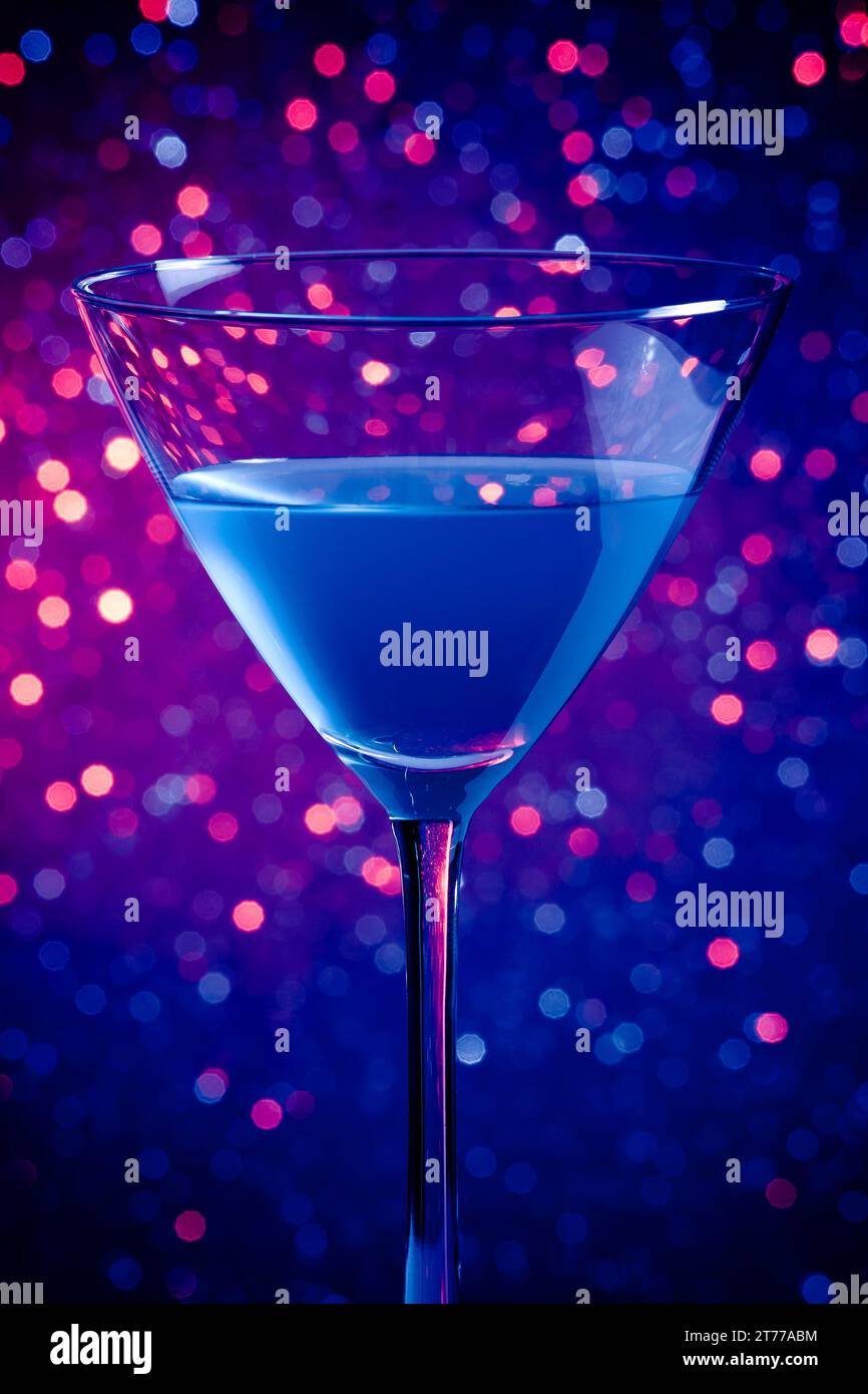Ein Glas blauer Cocktail auf blauem und violettem Hintergrund Stockfoto