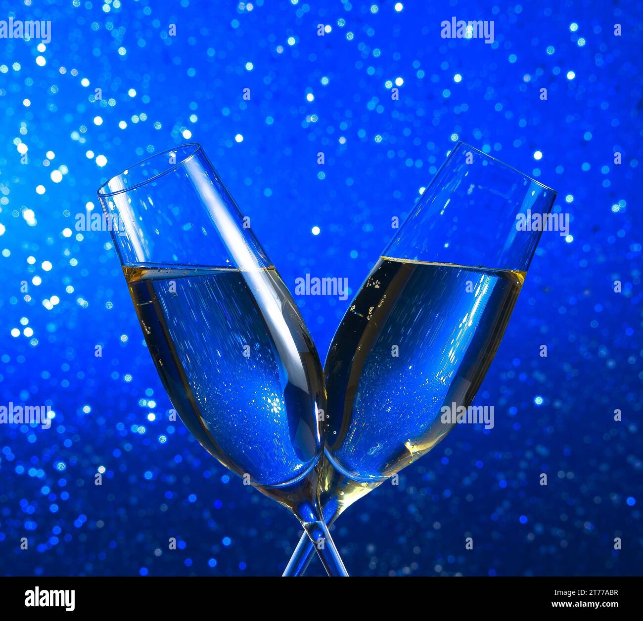 Champagnerflöten auf blauhellem Bokeh-Hintergrund mit Platz für Text Stockfoto
