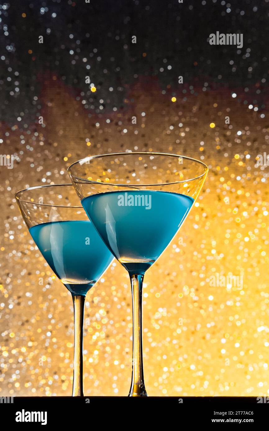 Ein paar Gläser blauer Cocktail auf goldenem, hellem Bokeh-Hintergrund Stockfoto