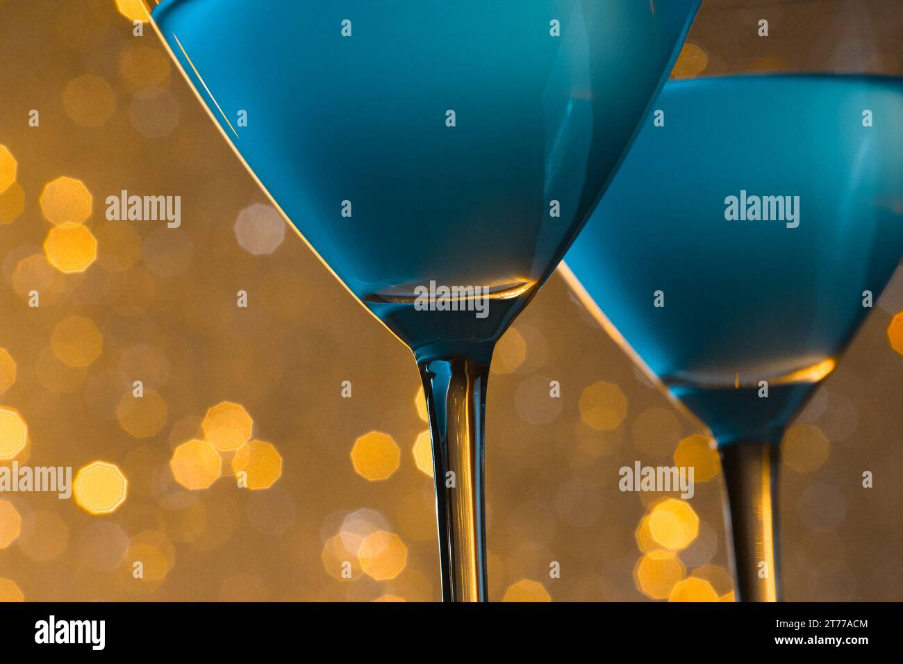 Detail der Gläser des blauen Cocktails auf goldenem, hellem Bokeh-Hintergrund Stockfoto