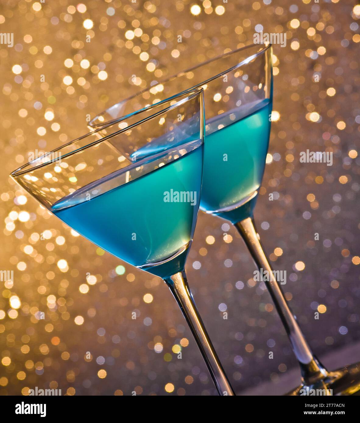 Zwei Gläser blauer Cocktail auf goldenem, hellem Bokeh-Hintergrund Stockfoto