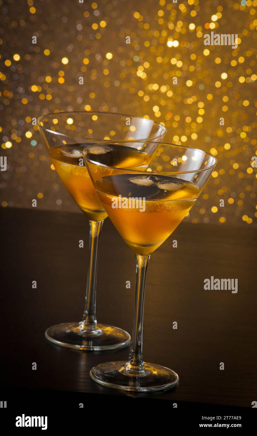 Zwei Gläser frischer Cocktail mit Eis auf goldenem, hellem Hintergrund auf dem Bartisch Stockfoto