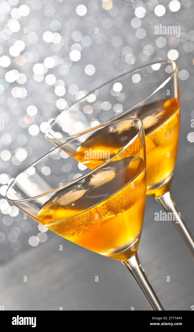 Zwei Gläser frischer Cocktail mit Eis auf silberfarbenem, hellem Bokeh-Hintergrund Stockfoto