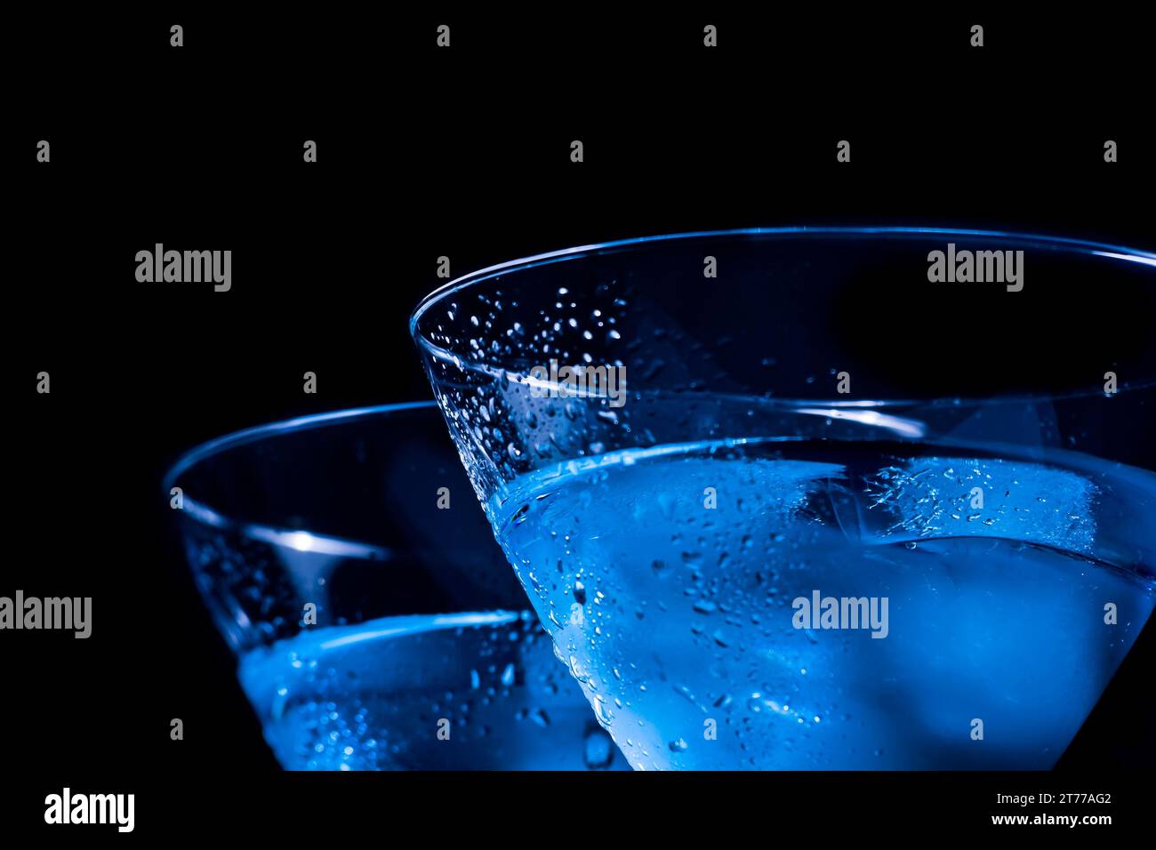 Ein paar Gläser frischer Cocktail mit Eis auf blauem Licht mit Platz für Text Stockfoto
