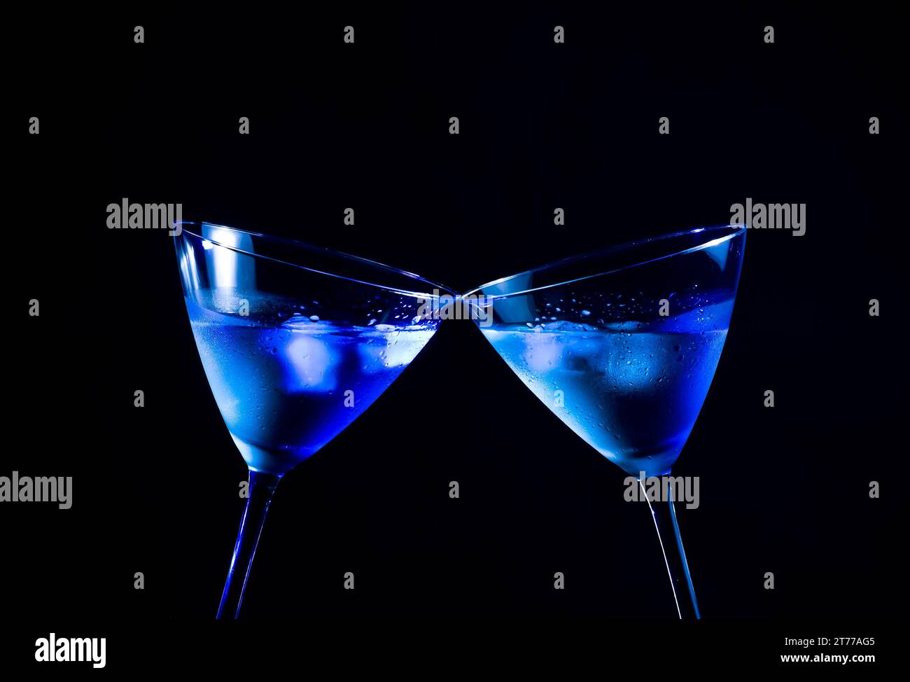 Ein paar Gläser frischer Cocktail mit Eis zaubern Anfeuerungen auf blaues Licht mit Platz für Text Stockfoto