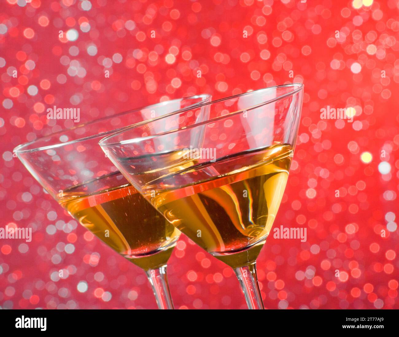 Detail der geneigten Cocktailgläser auf dem Bartisch auf rotem heller Bokeh-Hintergrund Stockfoto