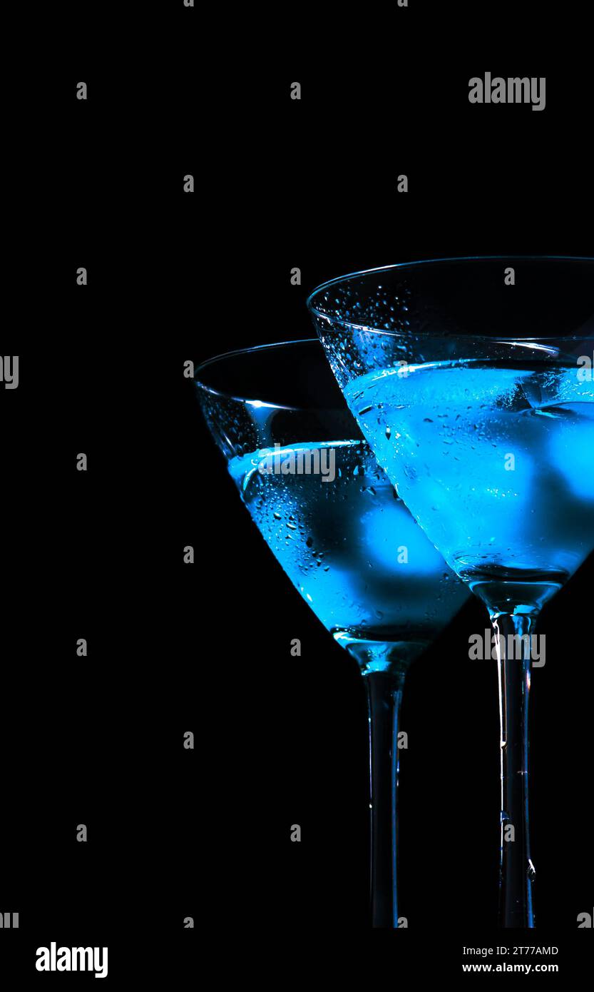 Gläser frischer blauer Cocktail mit Eis auf blauem Licht und schwarzem Hintergrund mit Platz für Text Stockfoto