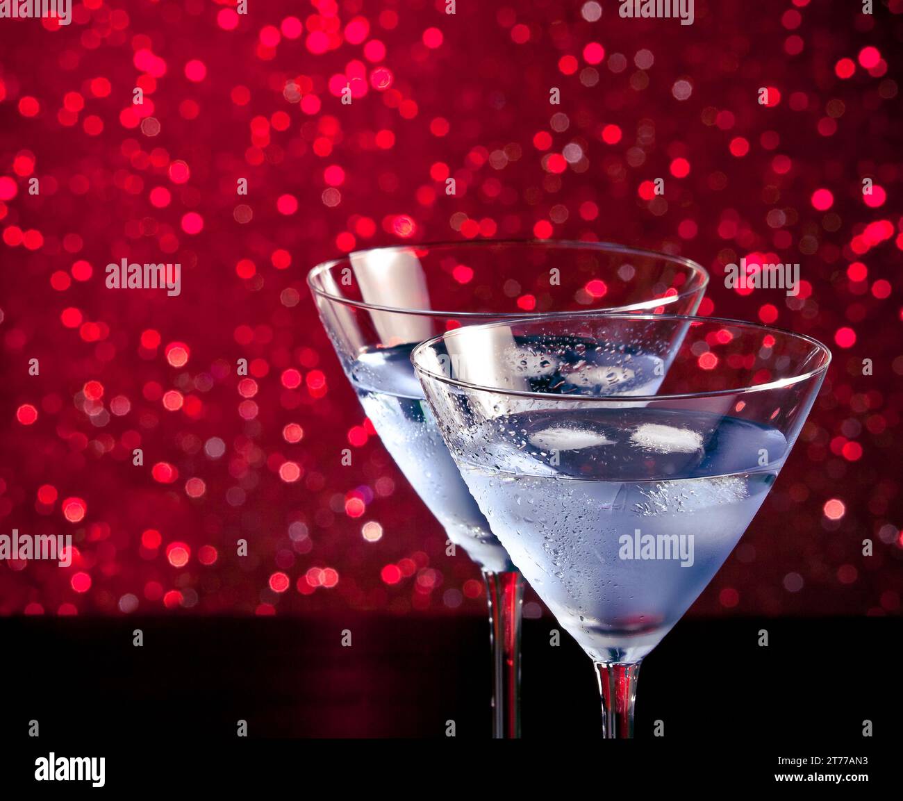 Gläser frischer Cocktail mit Eis auf rotem heller Bokeh-Hintergrund mit Platz für Text Stockfoto