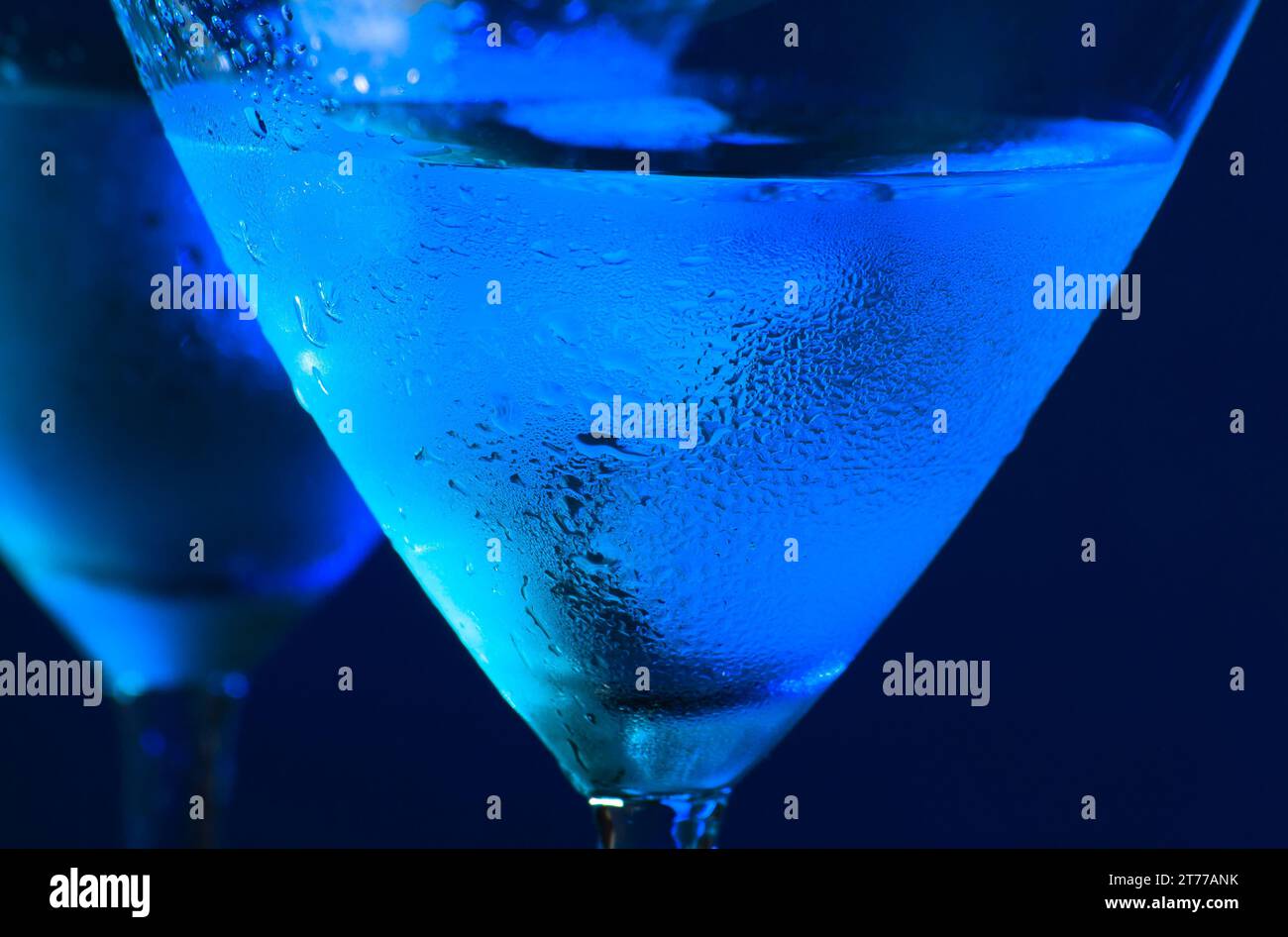 Detail der Gläser des frischen blauen Cocktails mit Eis auf blauem hellem Hintergrund Stockfoto