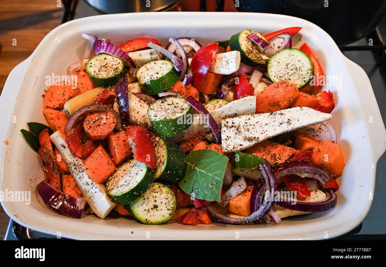 Home Kochen - Zubereitung von gebratenem Gemüse in einem für den Ofen vorbereiteten Gericht mit Butternusskürbis , Pastinaken Karotten , Zucchini und Paprika . Stockfoto