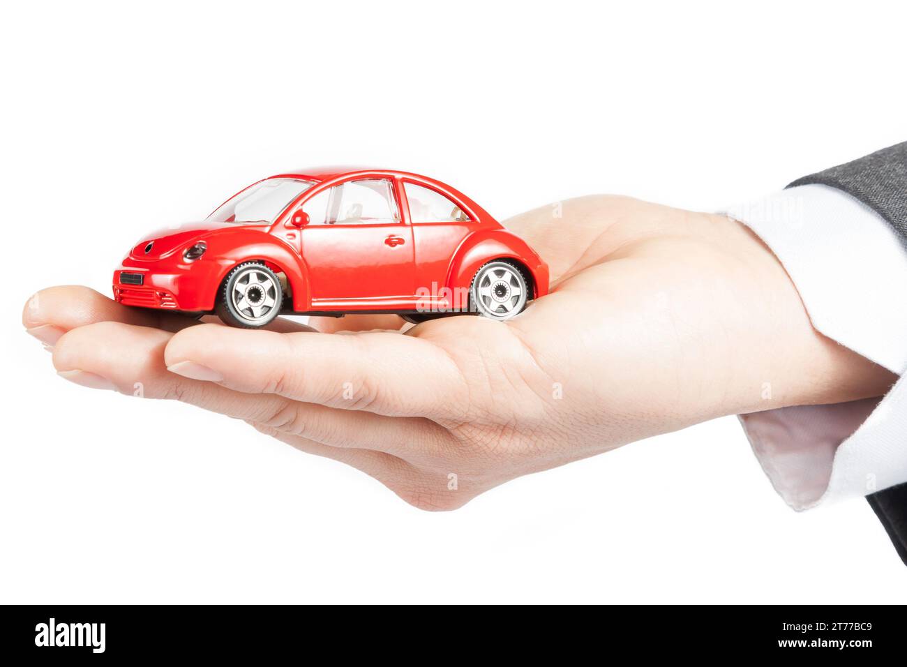 Spielzeugauto in der Hand eines Geschäftsmannes auf weißem Hintergrund, Konzept für Versicherung, Kauf, Miete, Kraftstoff oder Service- und Reparaturkosten Stockfoto