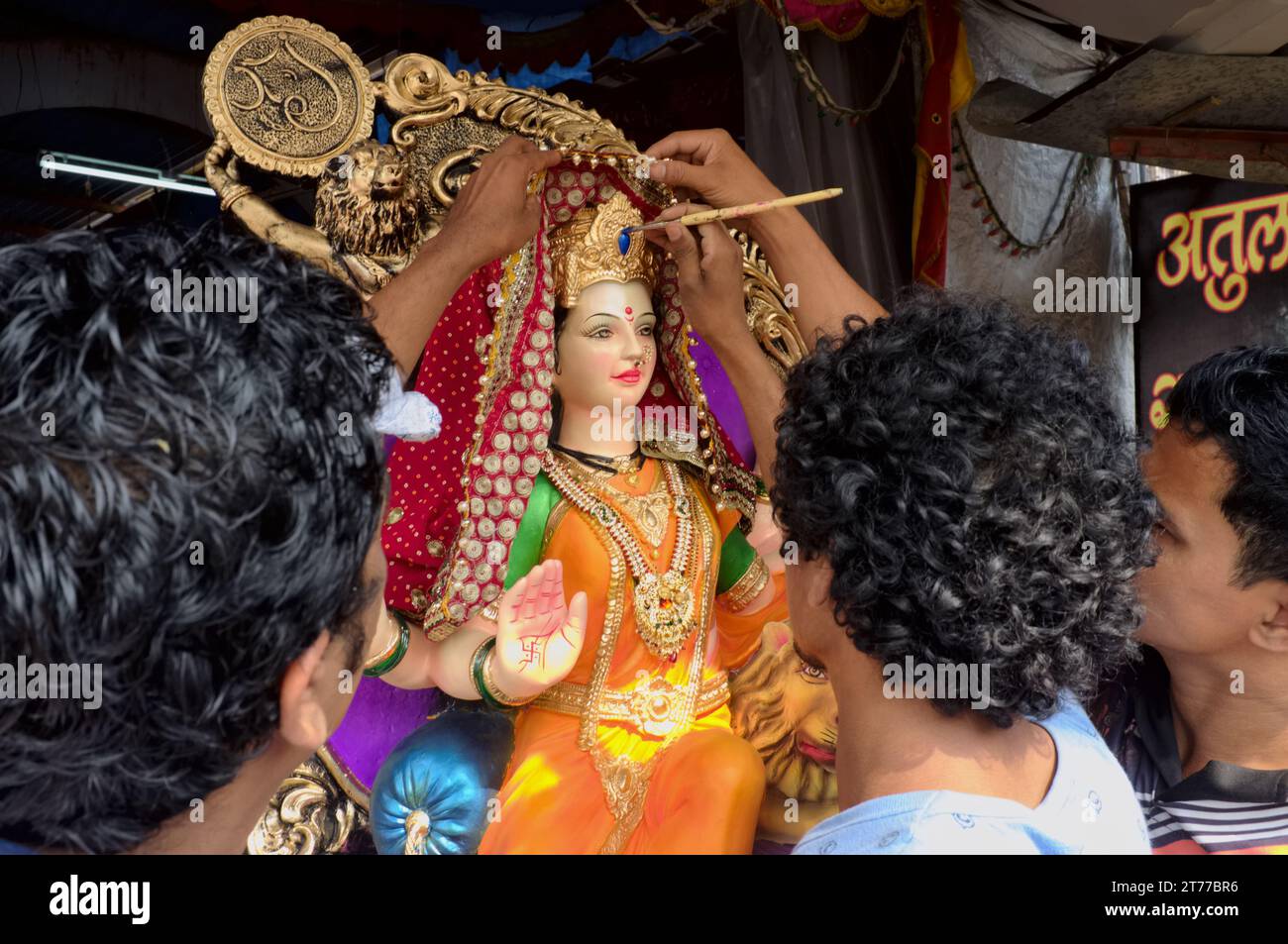 Für das Hindu-Festival Durga Puja geben Handwerker der Statue der Göttin Durga den letzten Schliff; in einer Werkstatt in Parel, Mumbai, Indien Stockfoto