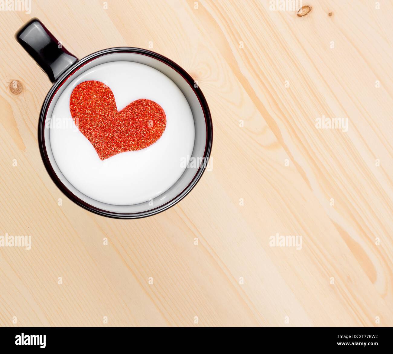Blick von oben auf eine Tasse Milch mit dekorativem Herz auf Holztisch mit Platz für Text, Konzept des valentinstag Stockfoto