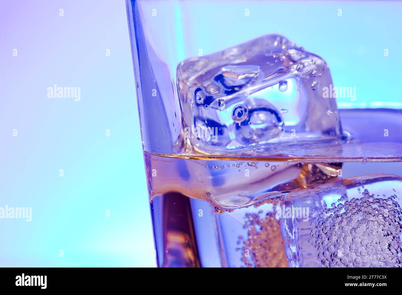 Glas alkoholisches Getränk mit Eis auf Disco Blaulicht mit Platz für Text Stockfoto
