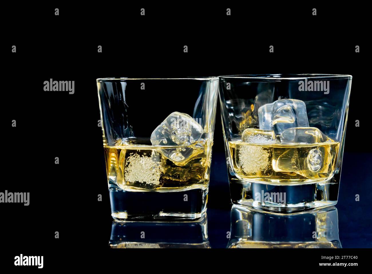 Zwei Gläser alkoholisches Getränk mit Eis auf Disco blaues Licht auf schwarzem Tisch mit Platz für Text Stockfoto