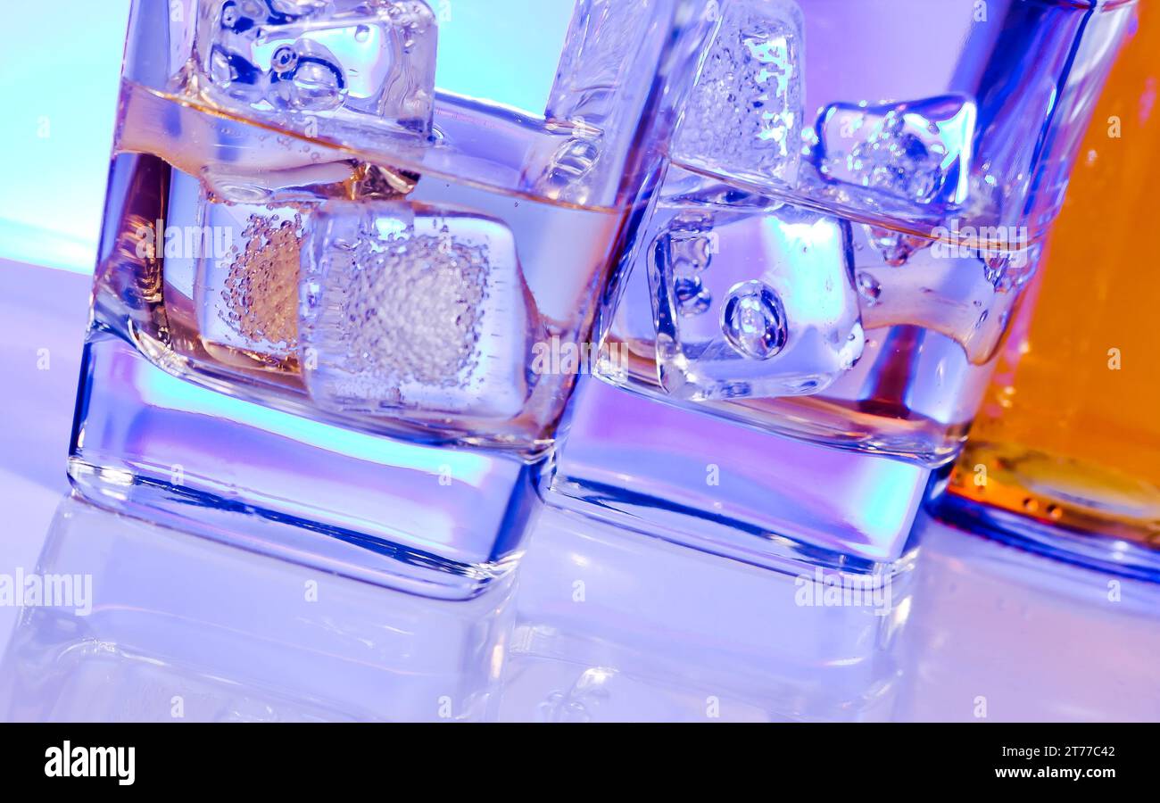 Zwei Gläser alkoholischer Drink Cocktail mit Eis auf Disco Blaulicht Stockfoto
