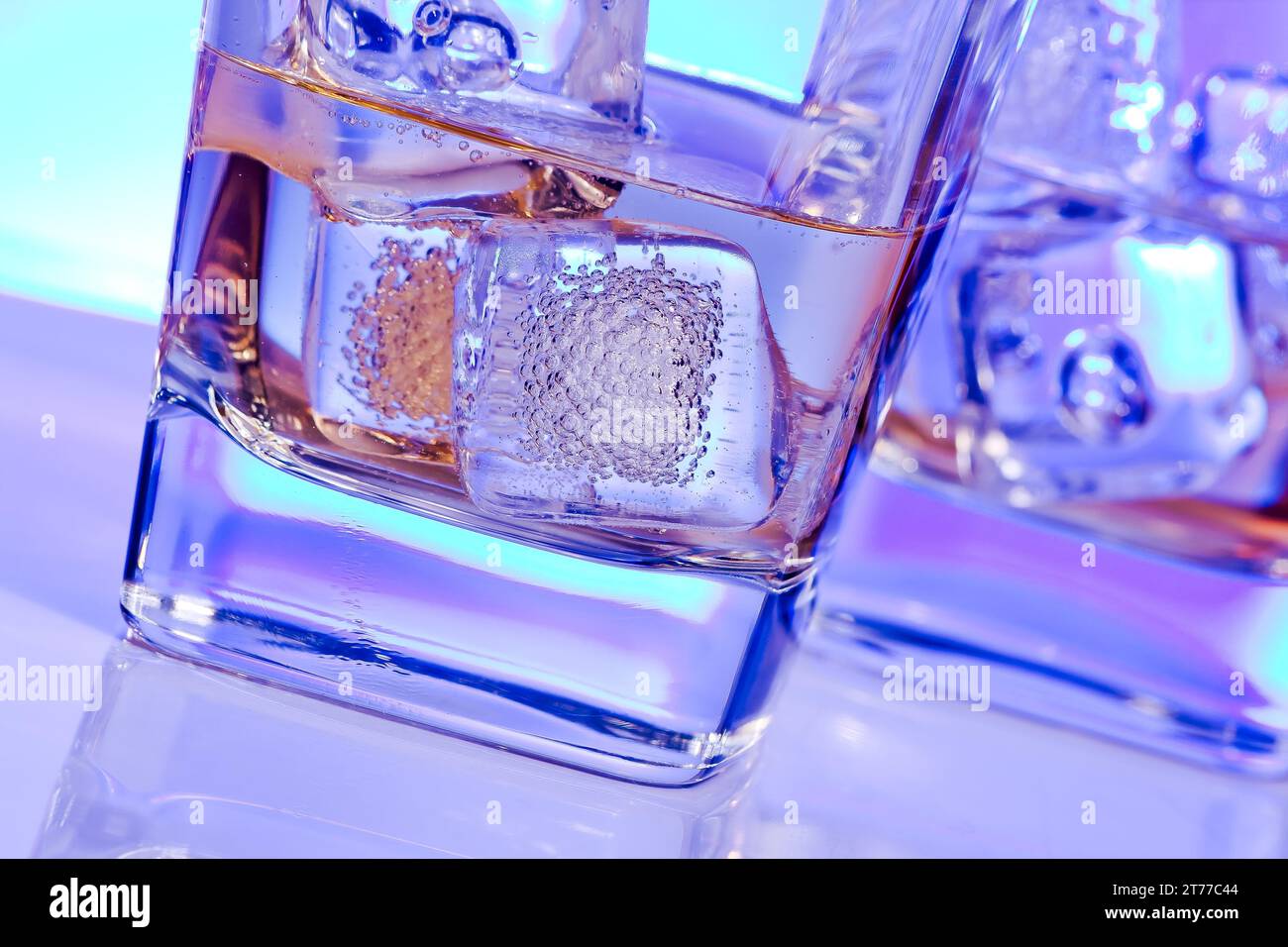 Gläser alkoholischer Drink Cocktail mit Eis auf Disco Blaulicht Stockfoto