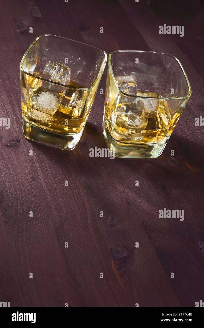 Zwei Gläser Whiskey mit Eis auf altem Holzhintergrund Stockfoto