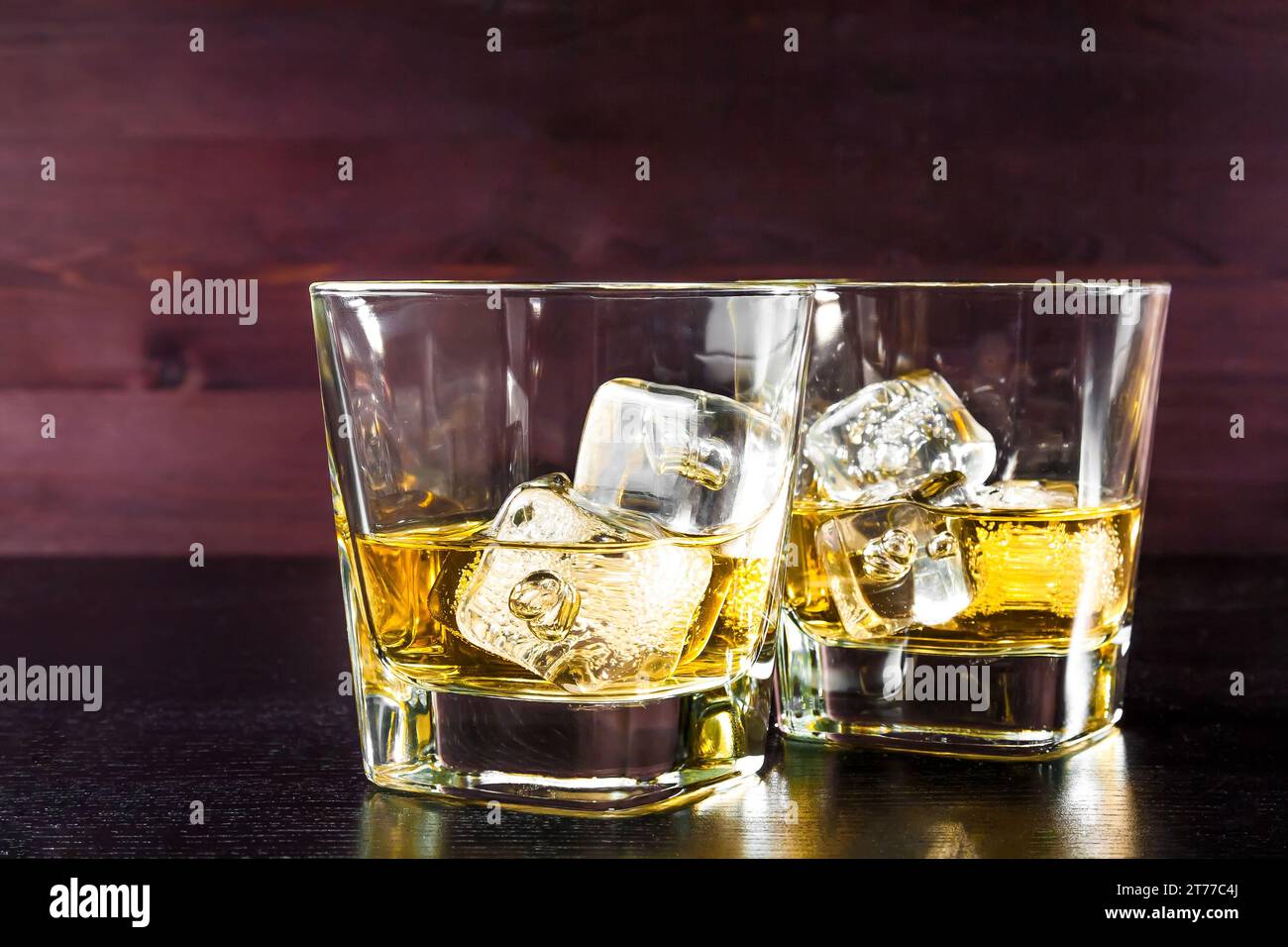 Getränkeserie, zwei Gläser Whiskey mit Eis auf altem Holztisch, Pub-Atmosphäre Stockfoto