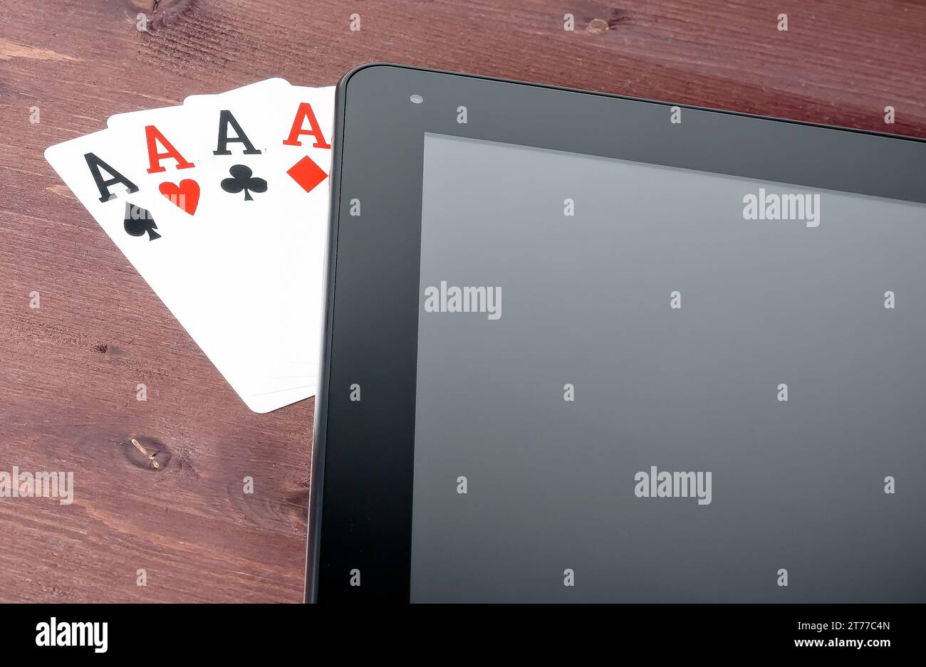 Detail der Pokerkarten auf einem digitalen Tablet-pc auf einem alten Holztisch, Konzept des texas Poker online Stockfoto