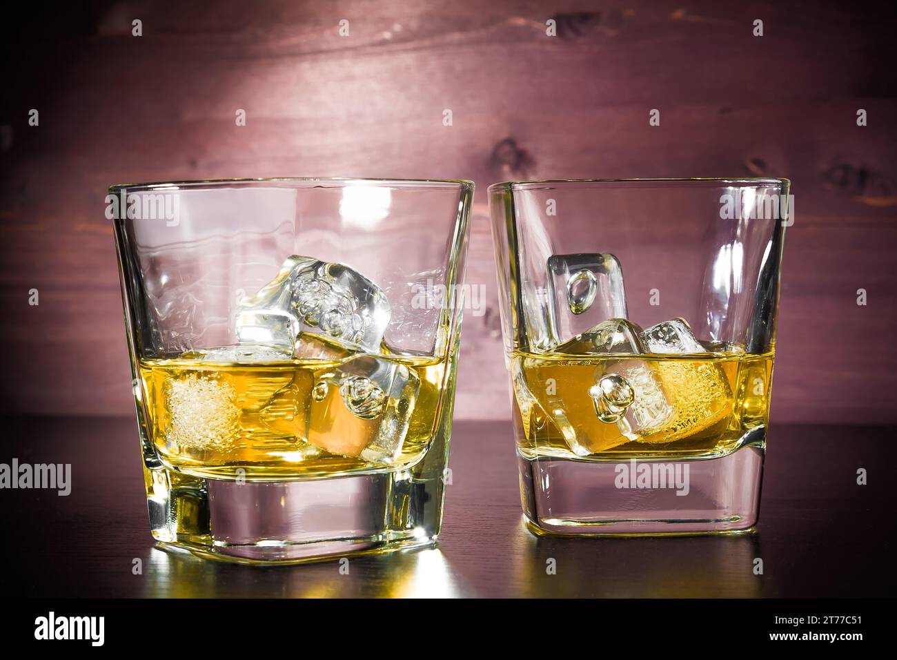 Getränkeserie, Gläser Whiskey mit Eis auf altem Holztisch, Pub-Atmosphäre Stockfoto