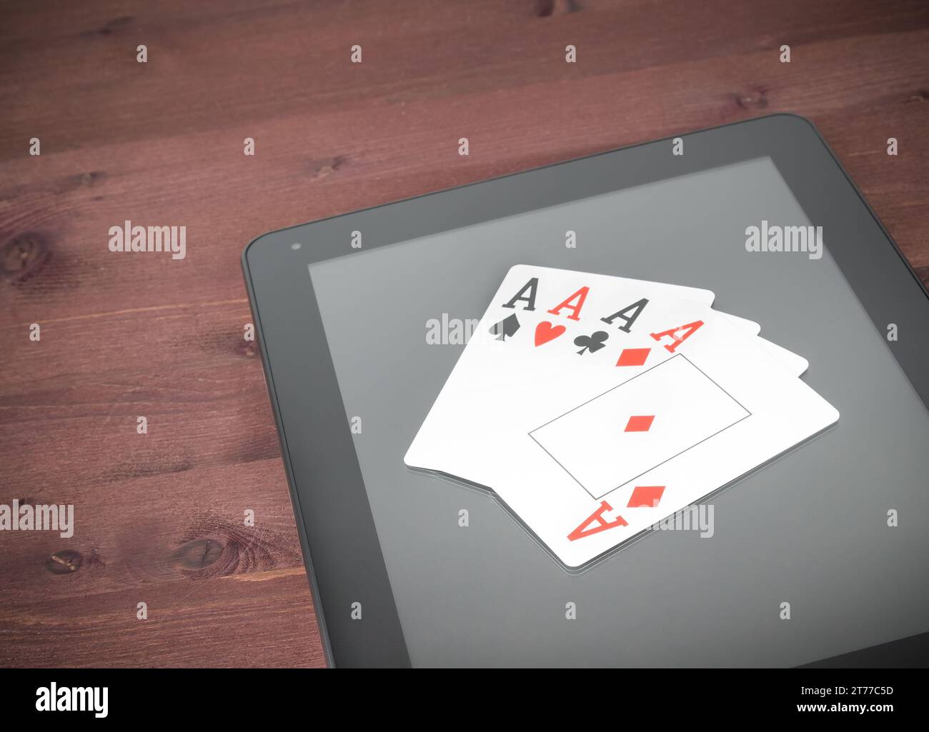 Pokerkarten auf digitalem Tablet-pc auf altem Holztisch, Konzept des texas Poker online Stockfoto