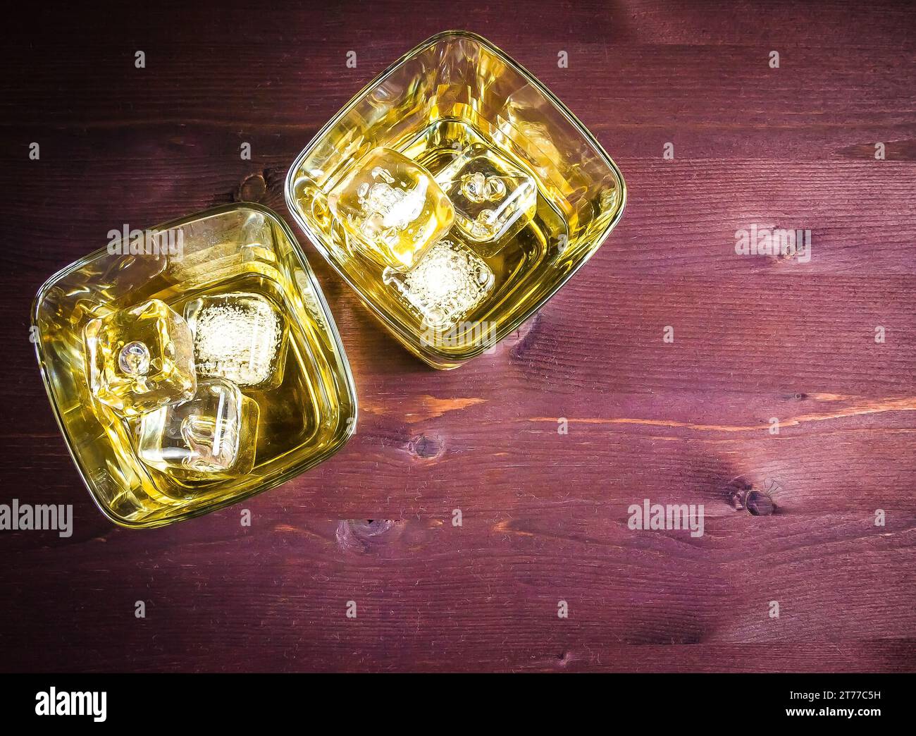 Oberer Blick auf zwei Gläser Whiskey mit Eis auf altem Holztisch Hintergrund mit Platz für Text Stockfoto