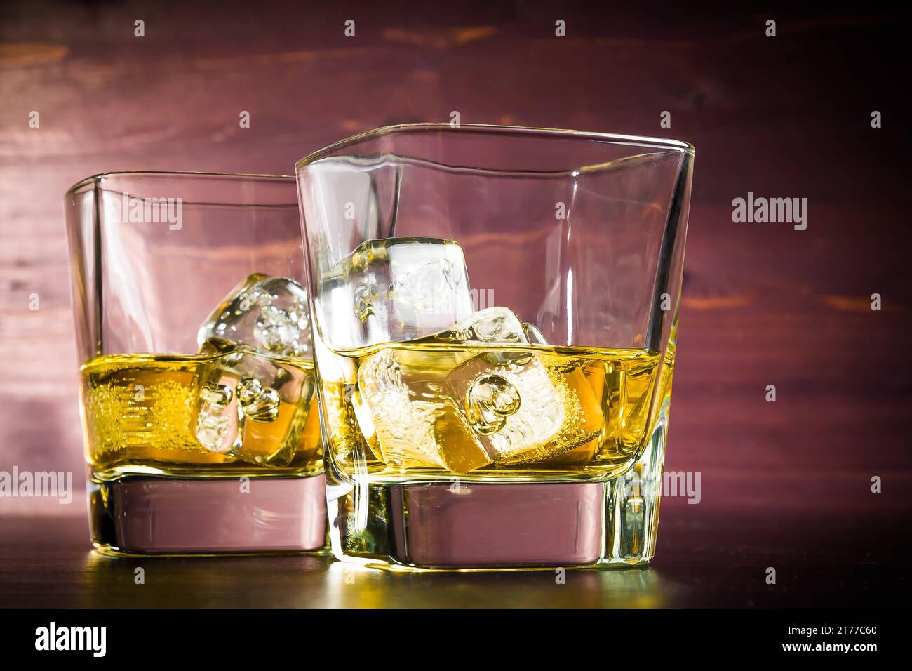 Zwei Gläser Whiskey mit Eis auf einem alten Holztisch, Pub-Atmosphäre Stockfoto