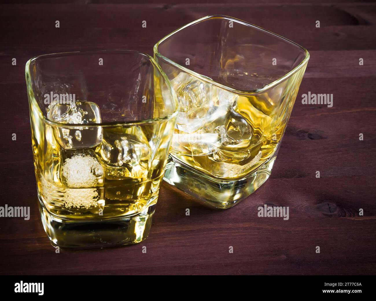 Zwei Gläser Whiskey mit Eis auf einem alten Holztisch, Pub-Atmosphäre Stockfoto