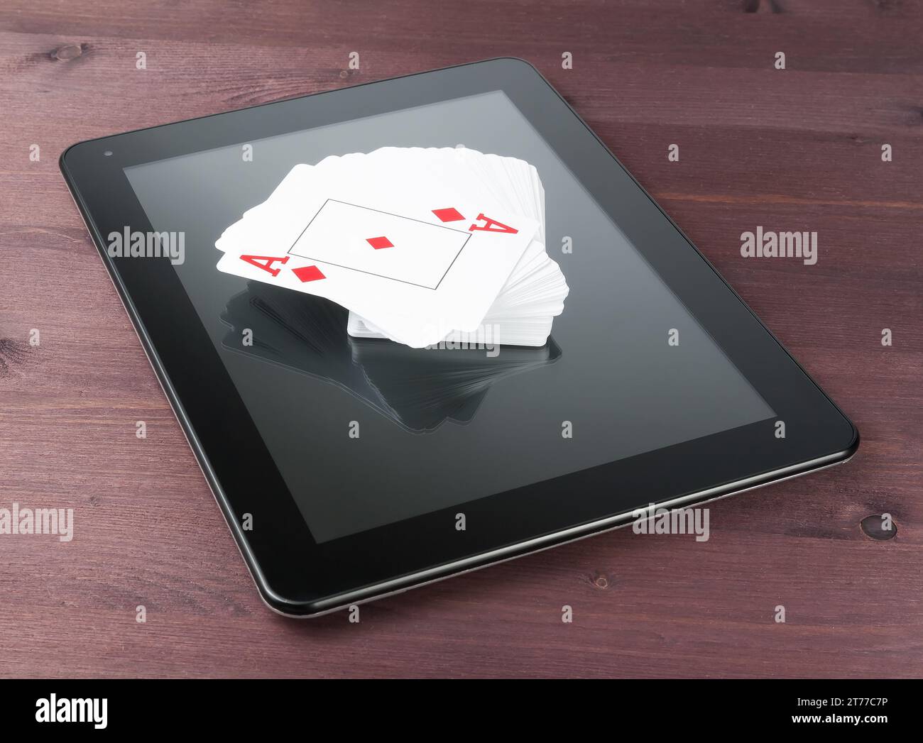 Kartenspiel auf einem digitalen Tablet-pc auf einem alten Holztisch, Konzept des texas Poker online Stockfoto