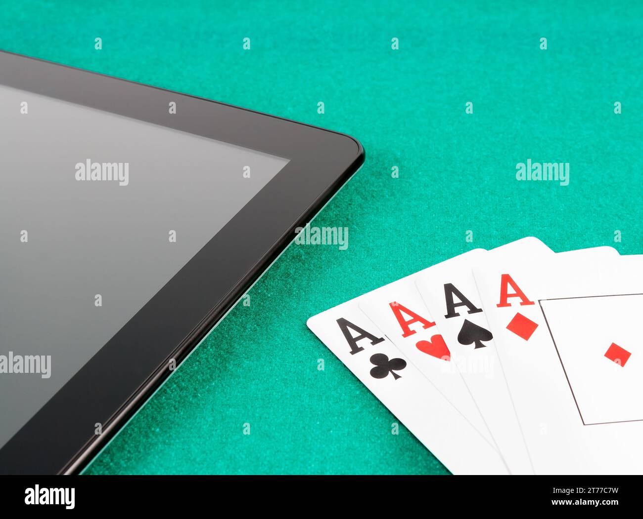 Pokerkarten in der Nähe eines digitalen Tablet-pcs auf grünem Spieltisch, Konzept des Poker online Stockfoto