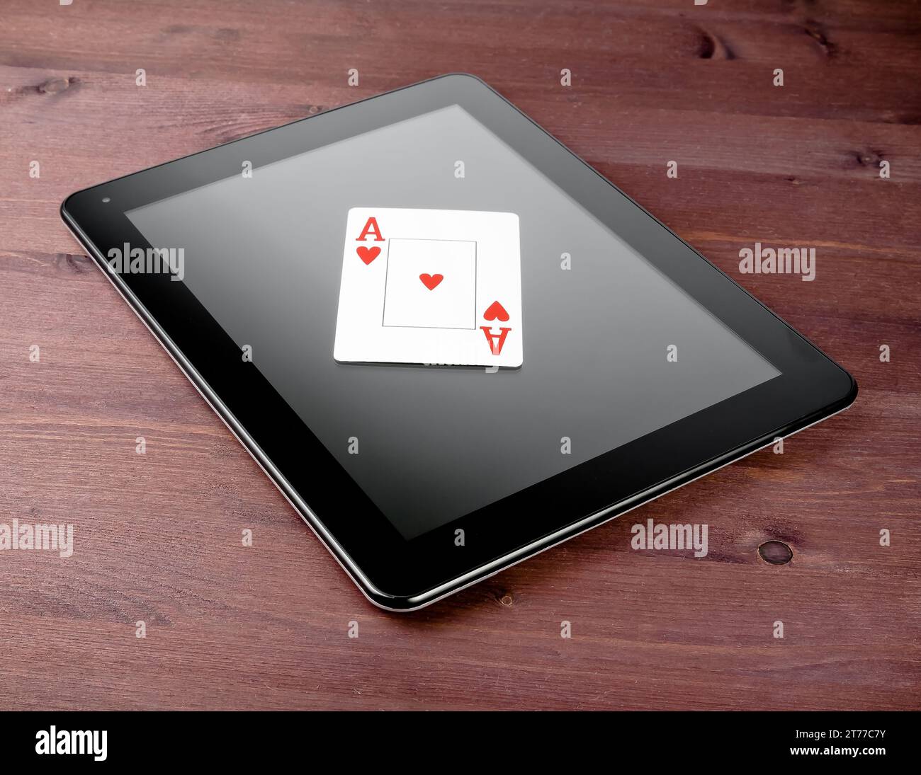 Einzelne Pokerkarte auf digitalem Tablet-pc auf altem Holztisch, Konzept des texas Poker online Stockfoto