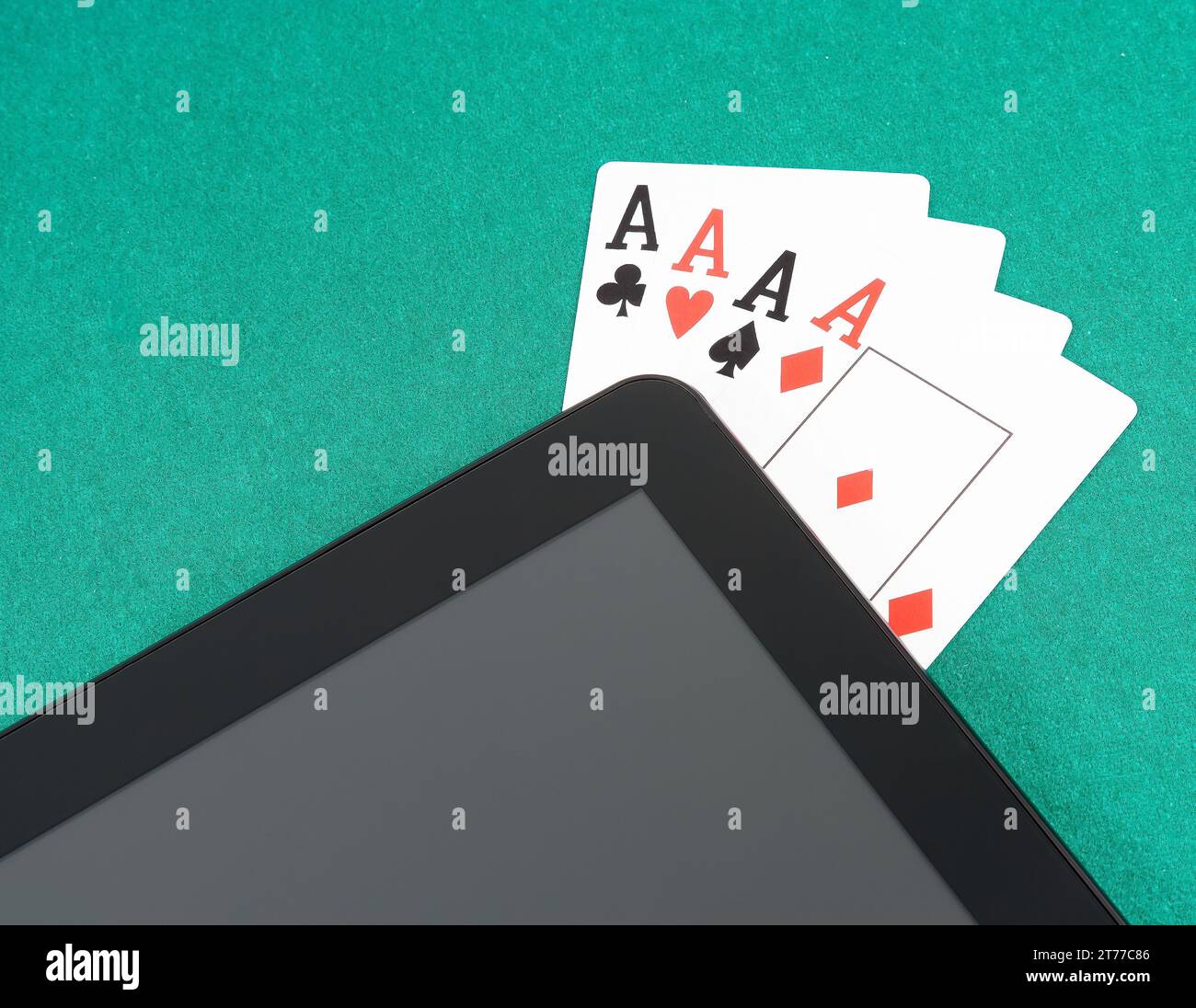 Pokerkarten in der Nähe eines digitalen Tablet-pcs auf grünem Tisch, Konzept des Poker online Stockfoto