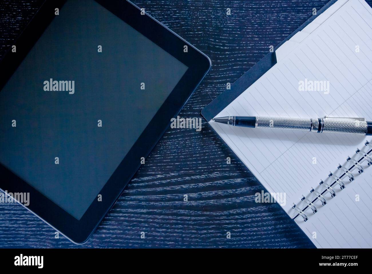 Digitaler Tablet-pc in der Nähe von Notizen im Büro auf schwarzem Holztisch, Konzept der neuen Technologie Stockfoto