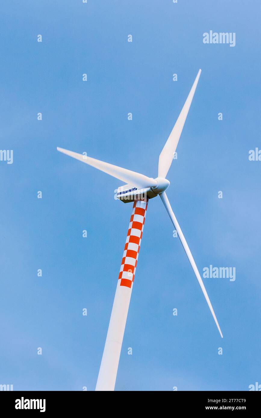 Windturbine in Bewegung unter blauem Himmel Stockfoto