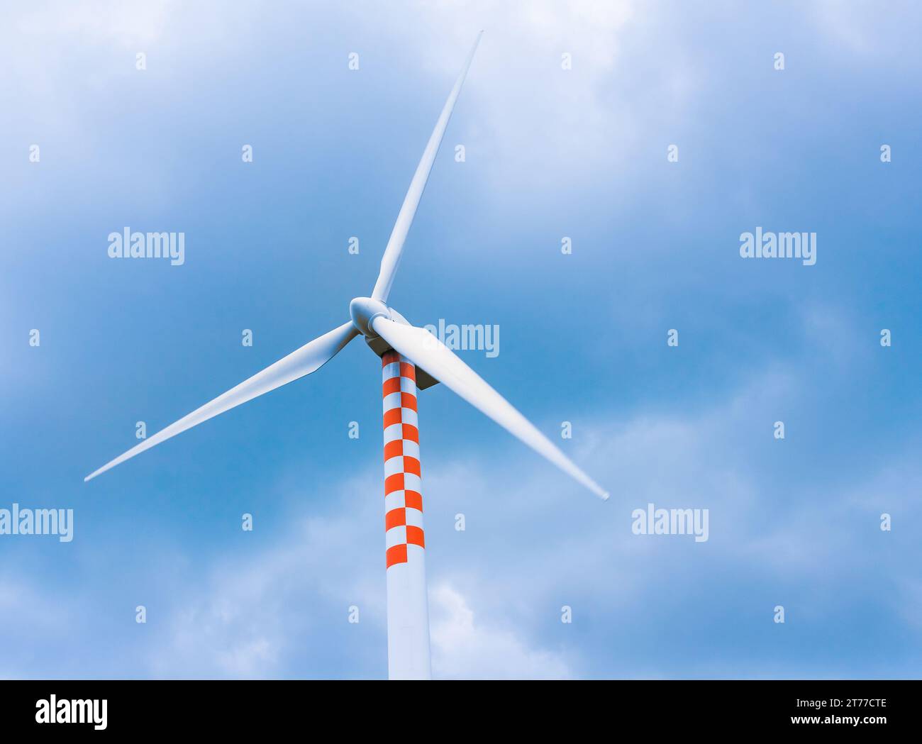 Windturbine in Bewegung unter blauem Himmel und Wolken mit Platz für Text Stockfoto