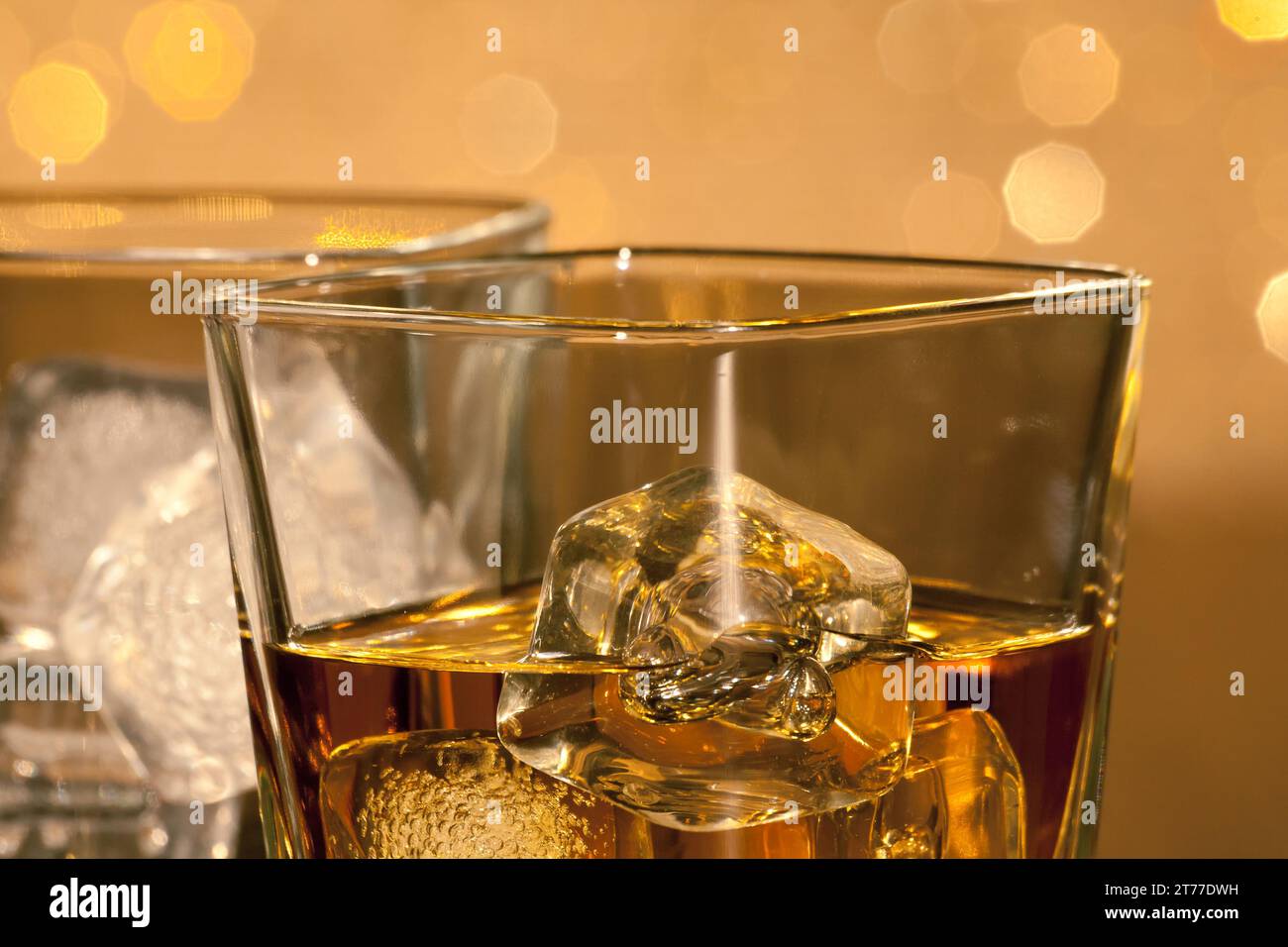 Nahaufnahme von Whiskey-Gläsern auf goldenem Bokeh-Hintergrund Stockfoto