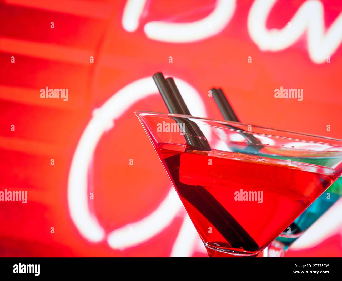 Detail eines roten Cocktails mit Neonhintergrund mit Platz für Text, Tanzdisco-Konzept Stockfoto