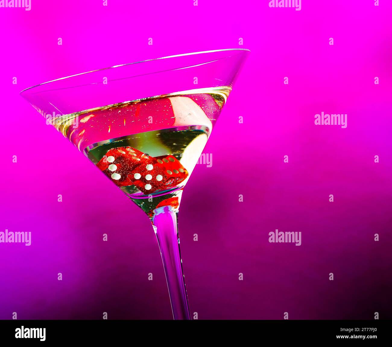 Rote Würfel im Cocktailglas auf violettem Hintergrund mit Platz für Text Stockfoto