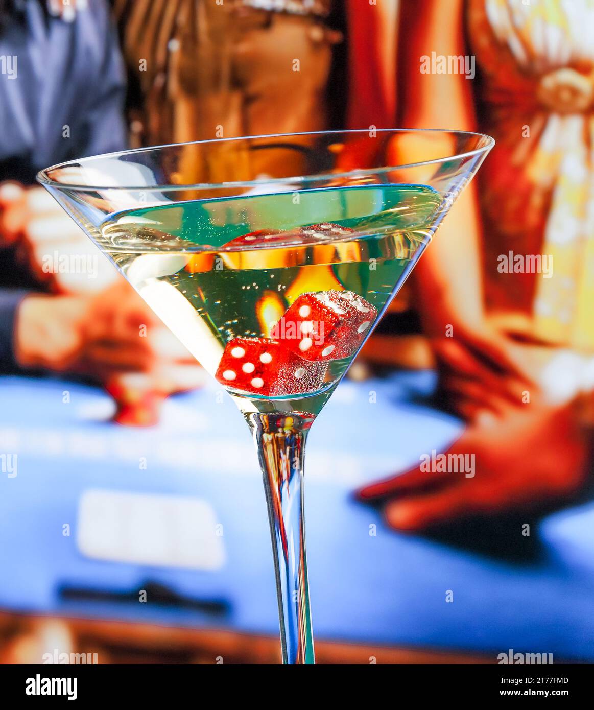 Rote Würfel im Cocktailglas vor dem Spieltisch, Casino-Konzept Stockfoto