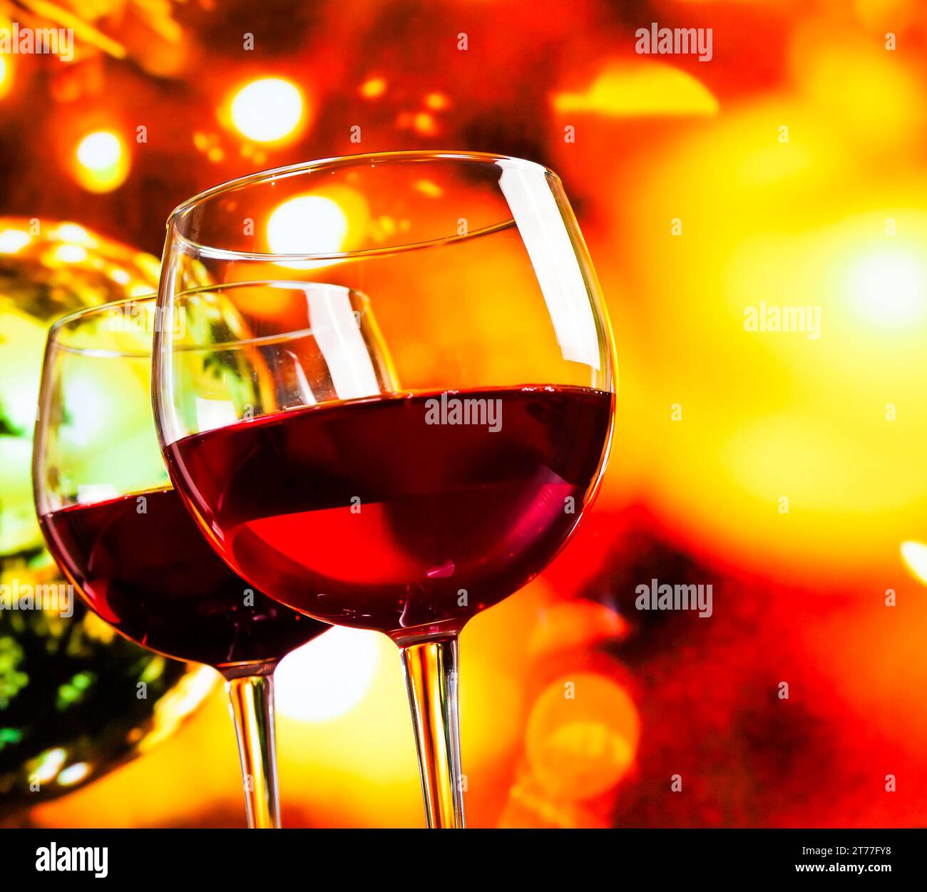 Rotweingläser vor farbenfrohen, unscharfen Lichtern im Hintergrund, festliches und unterhaltsames Konzept Stockfoto