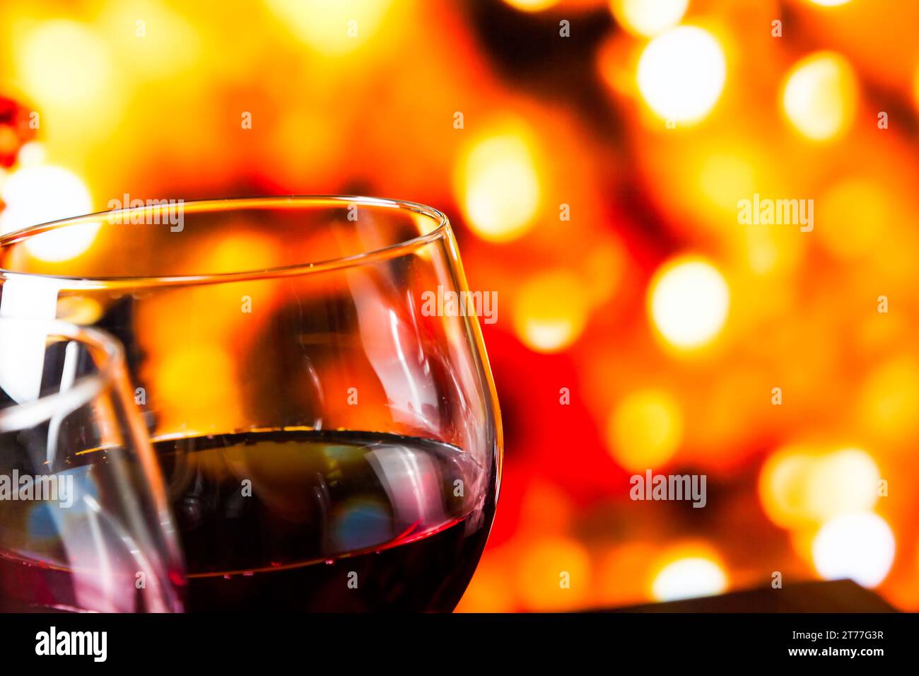 Rotweingläser vor farbenfrohen, unscharfen Lichtern im Hintergrund, festliches und unterhaltsames Konzept Stockfoto