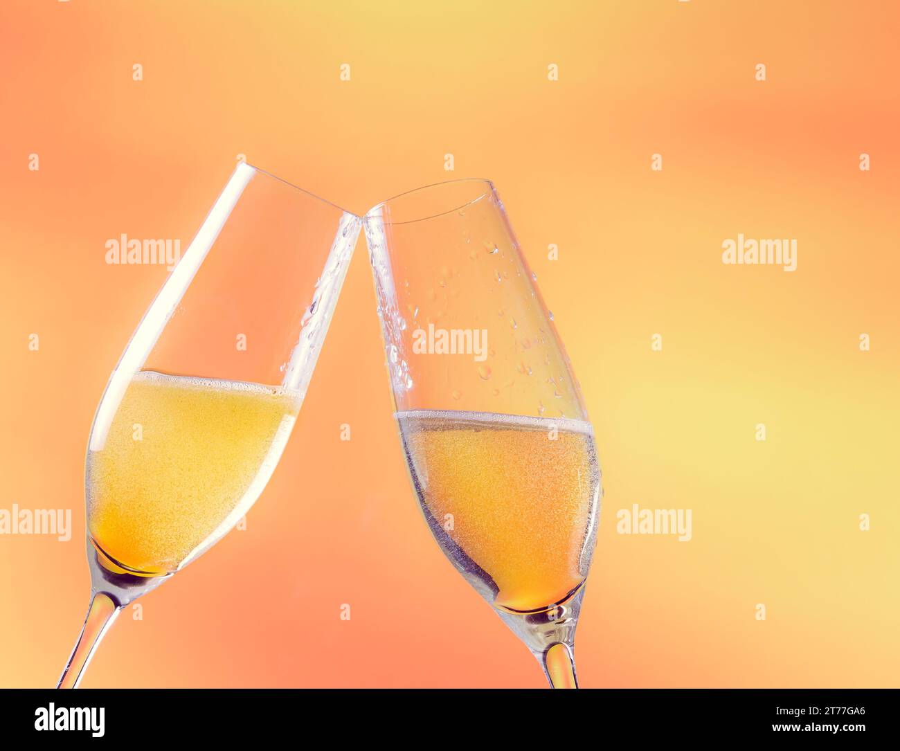 Zwei Sektflöten mit goldenen Blasen und Platz für Text auf goldenem Hintergrund Stockfoto