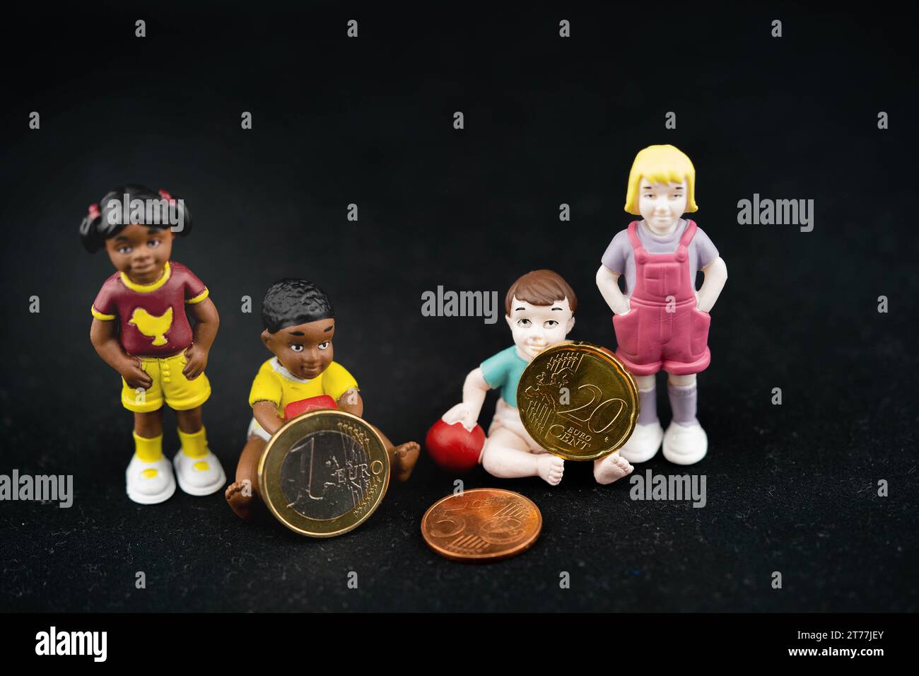 Kinderplastikfiguren mit Euro-Münzen, symbolisches Bild des Kindergeldes Stockfoto